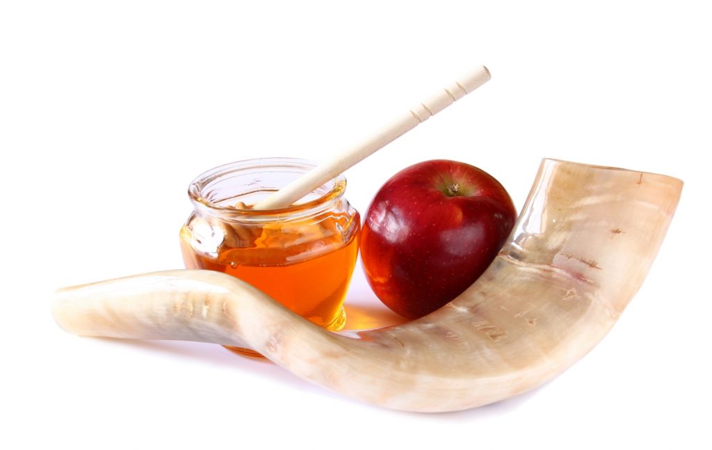 A shofar and a jar of honey and apple
